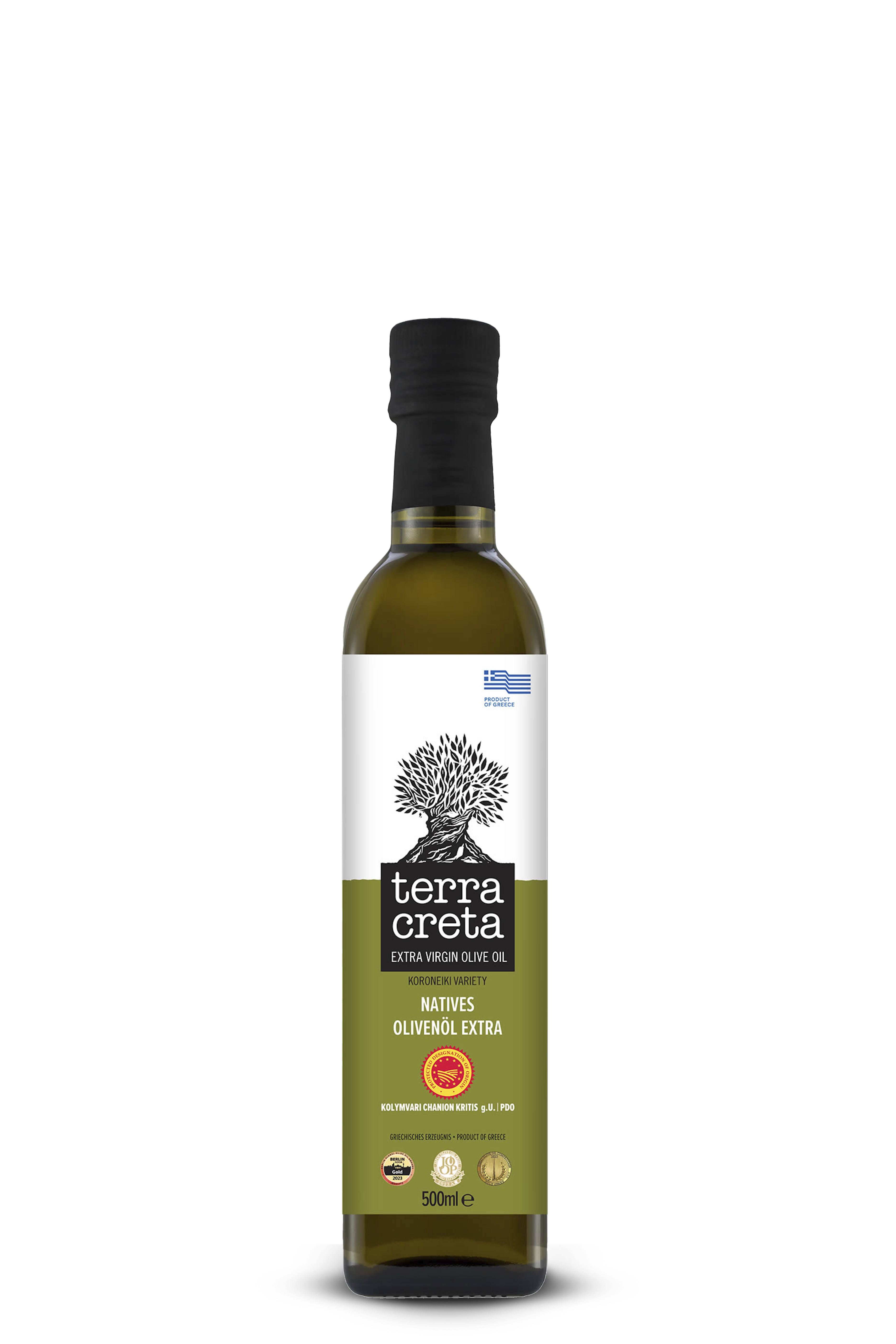 Dunkelgrüne Glasflasche mit schwarzem Schraubverschluss. Auf dem Etikett steht „terra creta – Extra Virgin Olive Oil“. Darunter: „Natives Olivenöl Extra, Koroneiki Variety, 500 ml“. Motiv: ein stilisierter Olivenbaum über grün-weißem Hintergrund.