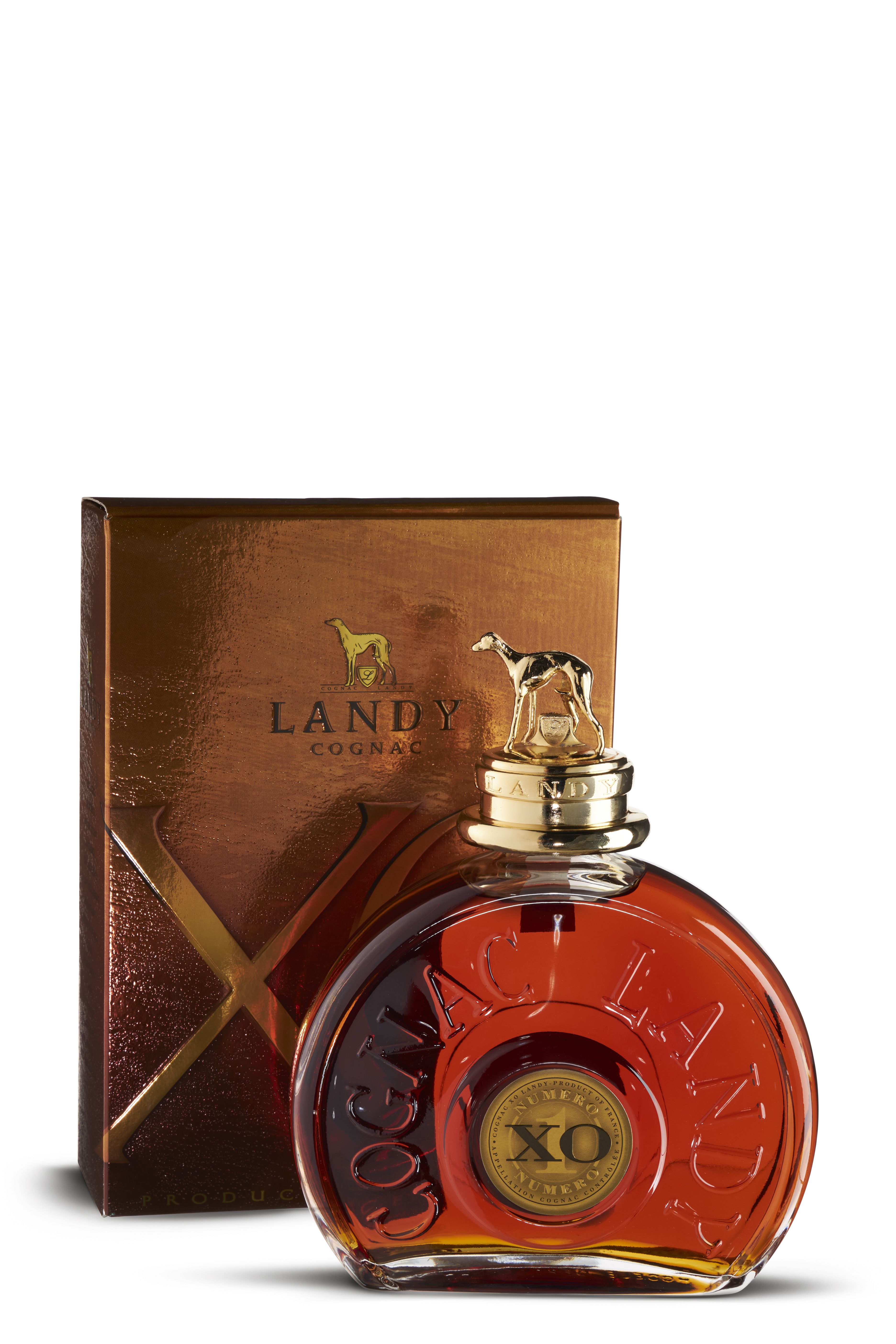 Ausgefallene Flasche Landy Cognac XO mit rundem Design und geprägter Schrift, davor eine bronzefarbene Geschenkbox. Der goldene Verschluss ist mit einer kleinen Hunde-Figur verziert. Der Cognac im Inneren glänzt in sattem Mahagoni-Bernstein.
