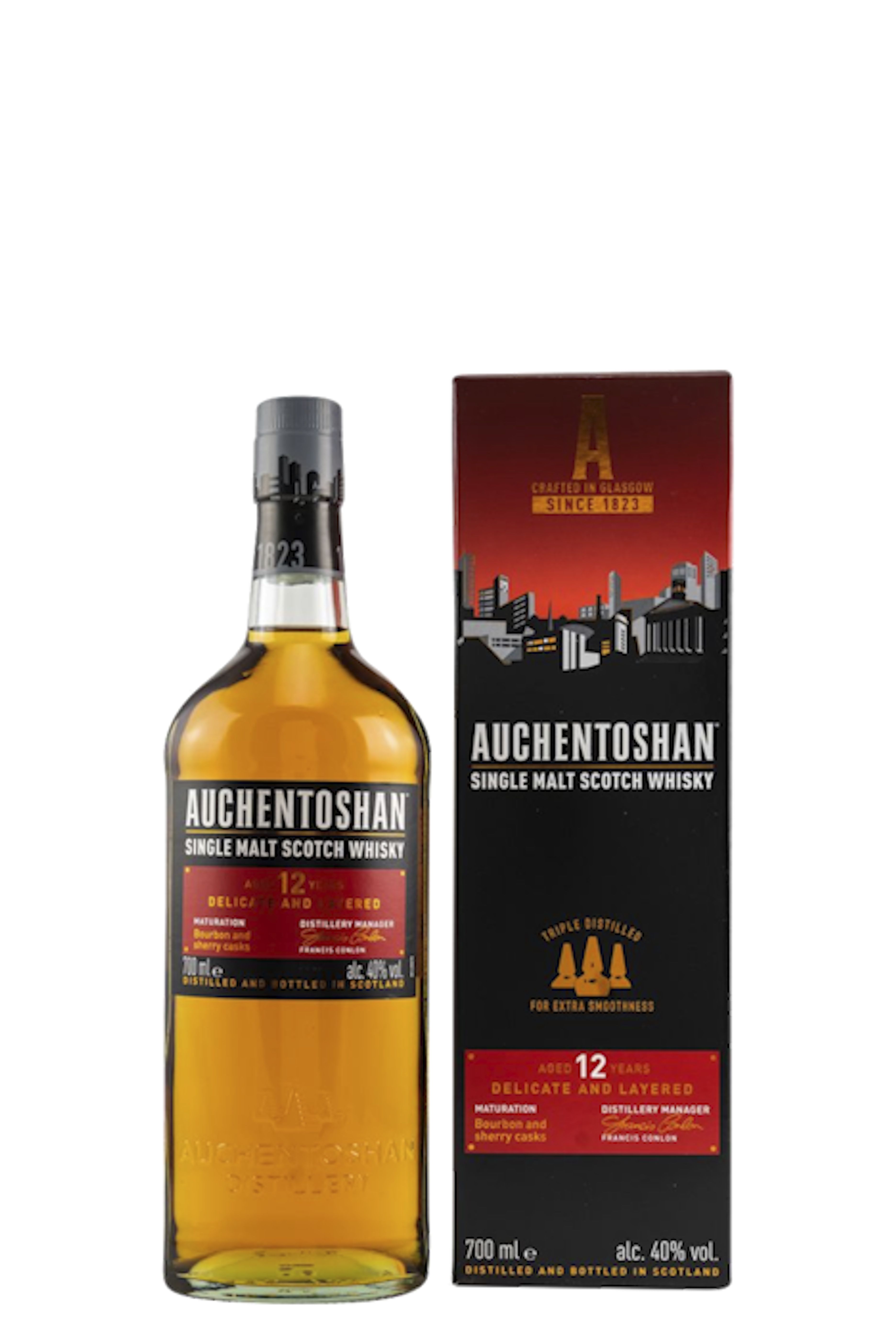 Flasche Auchentoshan 12 Years vor einer schwarzen Geschenkbox mit rotem Farbverlauf und Skyline-Motiv. Das moderne Design wirkt urban und prägnant. Der Whisky schimmert in warmem Goldton, betont durch das leuchtend rote Etikett und klare Linien.