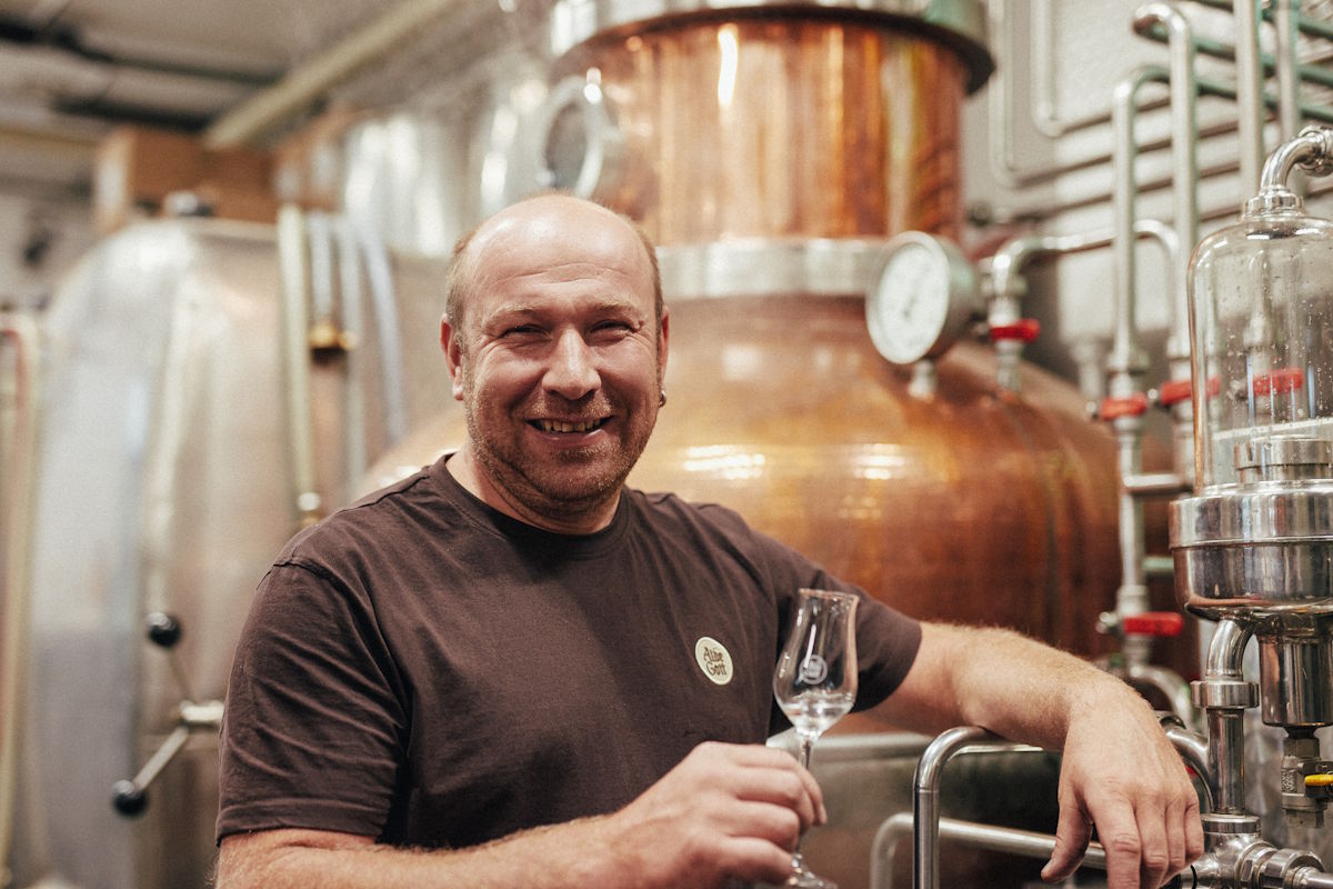 Brennmeister in traditioneller Destillerie mit Kupferbrennblase – Verkostung von hochwertigem Edelbrand in Handarbeit hergestellt.