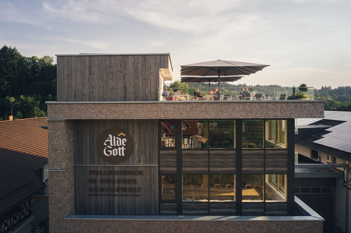 Moderne Vinothek der Alde Gott Winzer Schwarzwald eG mit Dachterrasse in der Abendsonne – stilvolle Architektur trifft Weingenuss.