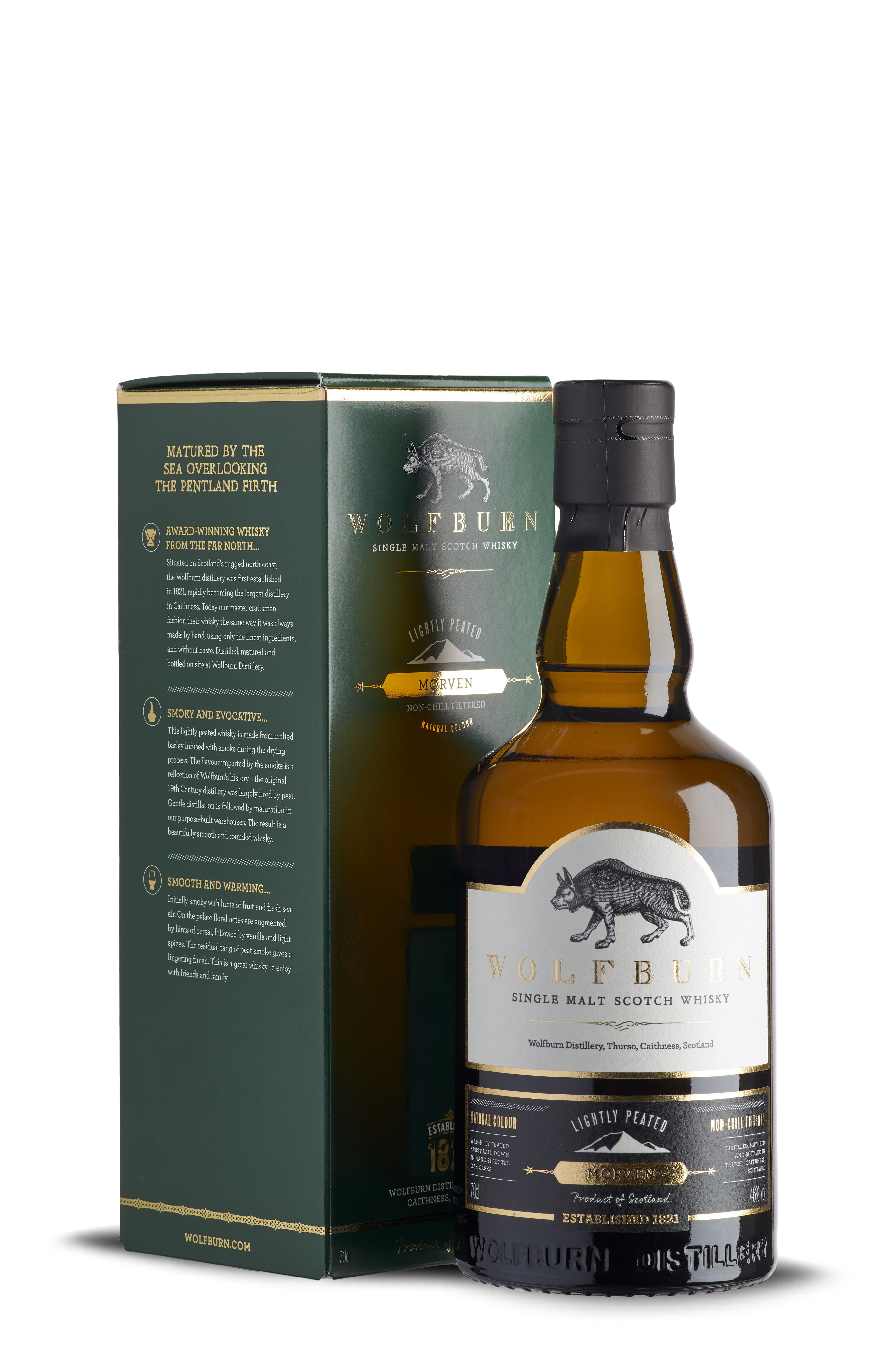 Flasche und Verpackung von Wolfburn Single Malt Scotch Whisky Morven. Flasche mit weißem Etikett, schwarzem und goldenem Text. Verpackung in Grün mit goldenen Schriftzügen und Logos.