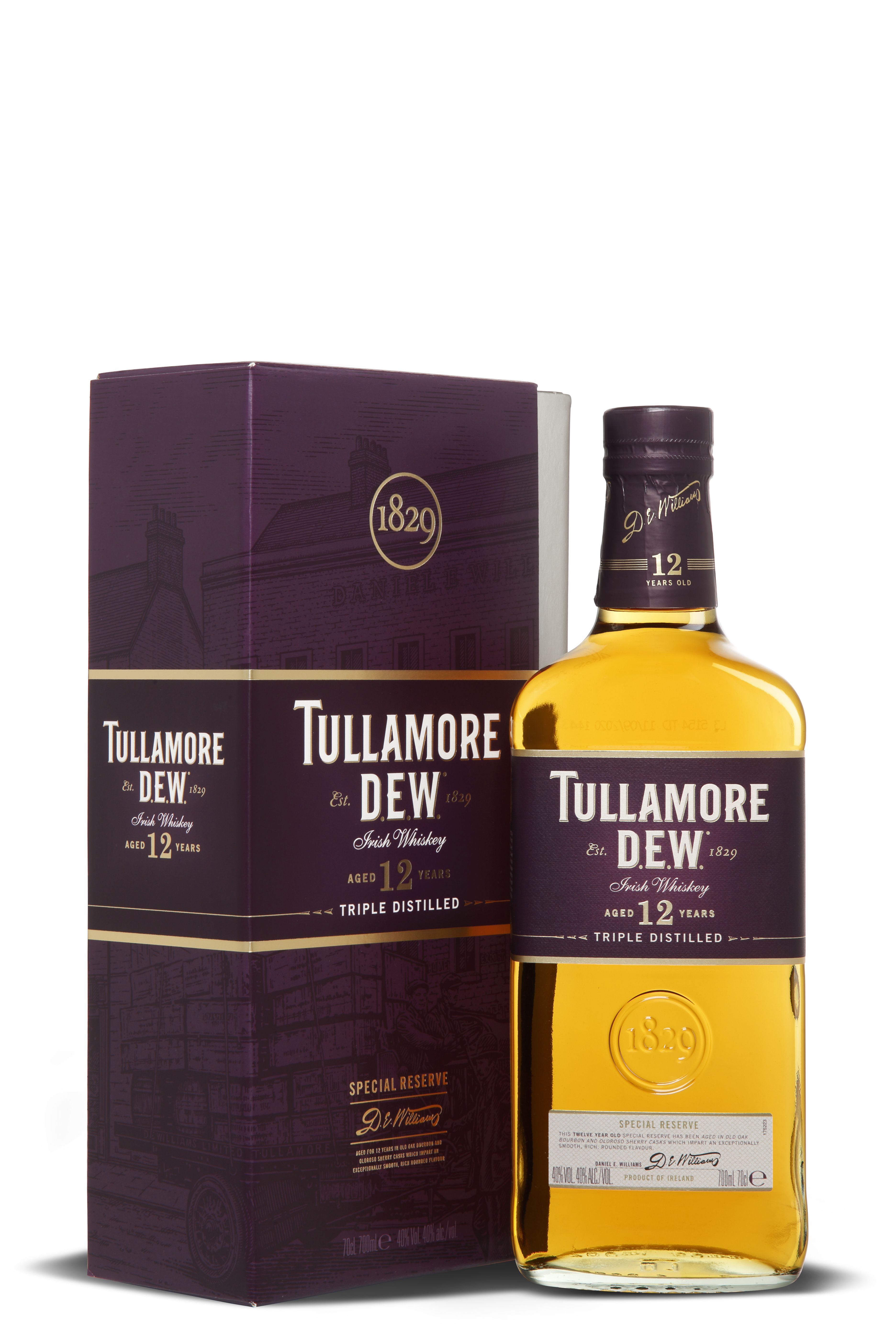 Eine Flasche Tullamore D.E.W. 12 Jahre Irish Whiskey mit goldenem Inhalt steht neben der dunkelvioletten Verpackung. Das Etikett zeigt Marke, Alter und dreifache Destillation in elegantem Weiß und Gold.